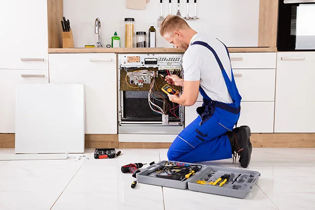 Appliance repair professional evaluating an open residential appliance