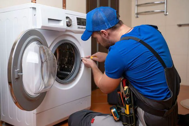Appliance service professional inspecting a front-load washing machine