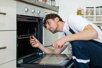 Service professional checking the interior of a residential oven