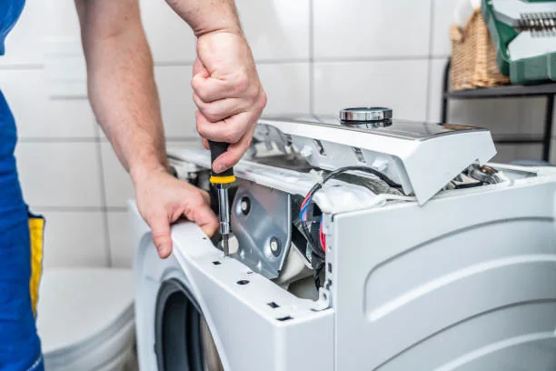 Close-up of a professional servicing washing machine controls